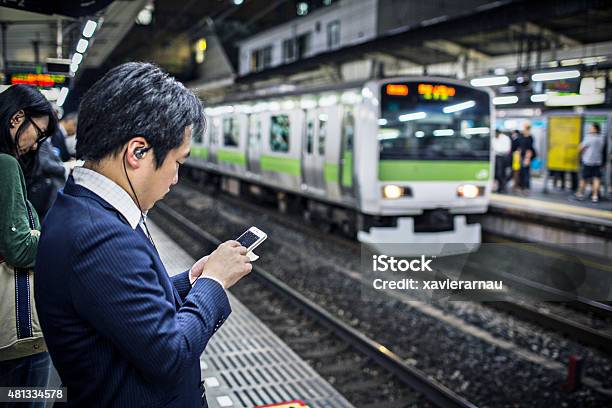 Playing Games On The Mobile Phone While Waiting For The Train Stock Photo - Download Image Now