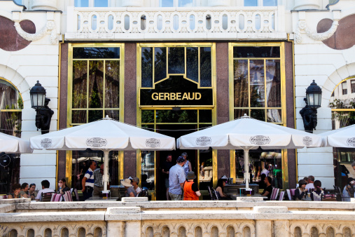 Budapest, Hungary - July 9, 2013: Cafe Gerbeaud, situated at Vorosmarty square in Budapest is one of the most famous coffeehouses in Europe. The company was started in 1858 by Henrik Kugler, who travelled and learned skills across Europe. He met Emil Gerbeaud in Paris and invited him to Budapest to declare him to his associate. Later, Gerbeaud took over Kuglers store piece by piece and retained the original name, which still stands today.