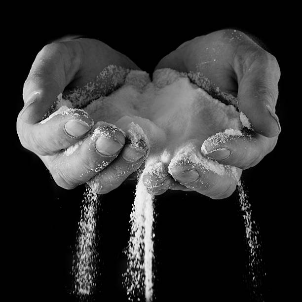 istock Male hands with salt pouring through 481338404
