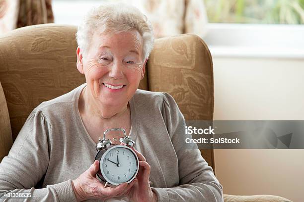 Senior Woman Holding An Alarm Clock Stock Photo - Download Image Now - Clock, Senior Adult, 80-89 Years