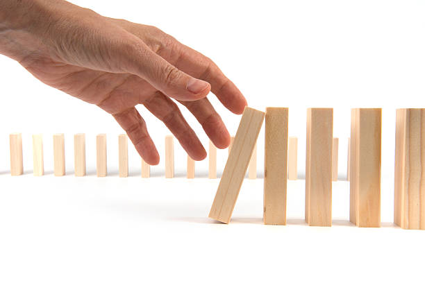 istock too late -Hand wants to hold falling Domino pieces cascade 481345178