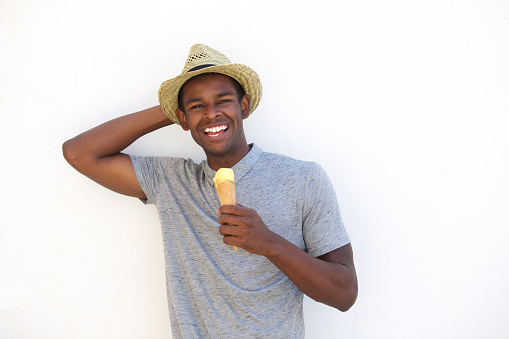 Close up portrait of a happy african american guy enjoying ice cream cone