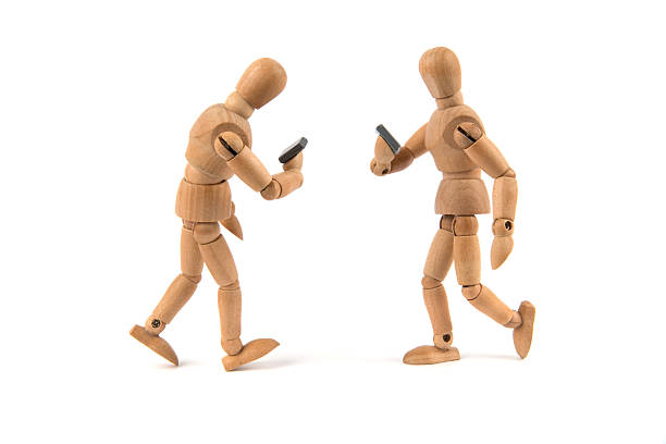 istock walking wooden mannequin looking only to smartphone 481349856
