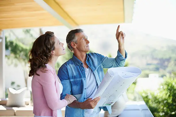 A mature couple looking at architectural plans together at home