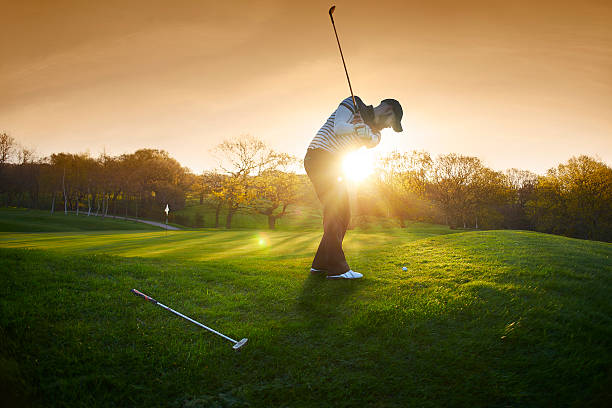 iluminação de campo de golfe com golfista chipping na verde - traditional sport sports flag golf flag golf - fotografias e filmes do acervo