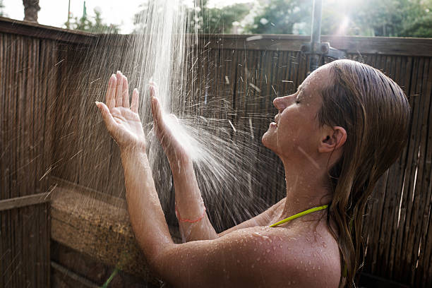 istock Woman enjoying while taking a shower outdoors. 481362464