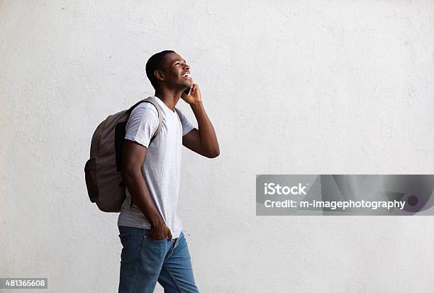 Happy Student Walking And Talking On Mobile Phone Stock Photo - Download Image Now - University Student, Backpack, White Background