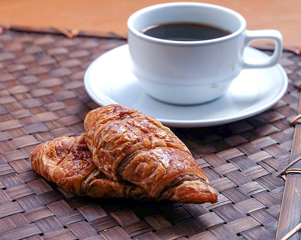 Café-da-manhã com uma xícara de café, croissants preto - foto de acervo