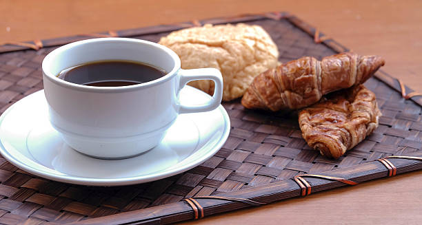 Pequeno-almoço com copo de café e croissants preto - fotografia de stock