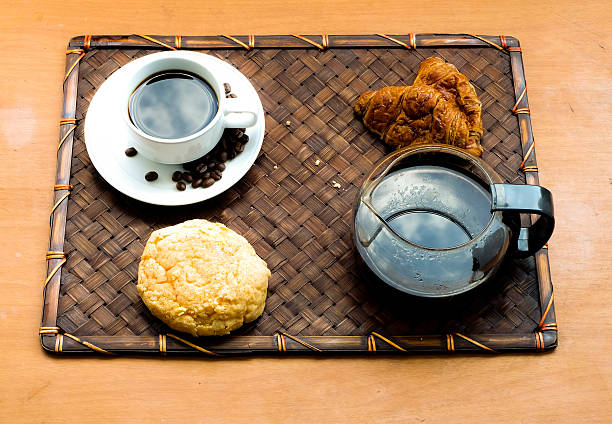 Pequeno-almoço com copo de café e croissants preto - fotografia de stock