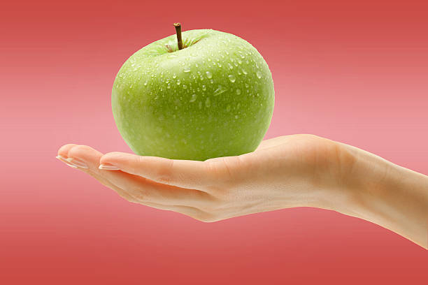 istock Female hand with green apple 481368454