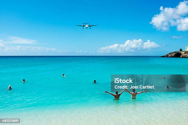 Greeting A Plane On St Maarten Stock Photo - Download Image Now - Sint Maarten, Airplane, Arms Outstretched