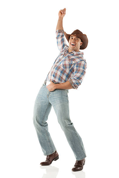 istock Smiling cowboy looking at camera with hand raised 481376573