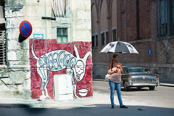Havana, Cuba - May 6, 2015: A woman shades herself from Cuba's hot sun