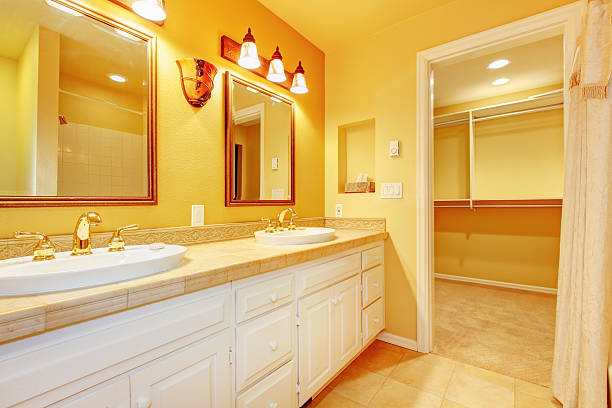 istock Bathroom with white cabinets and gold yellow walls. 481377621
