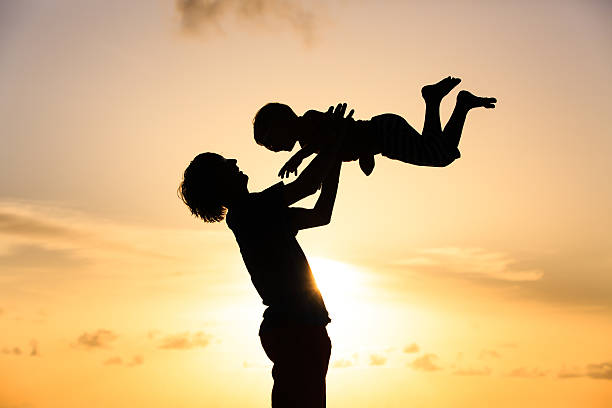 istock father and little son silhouettes play at sunset 481380180