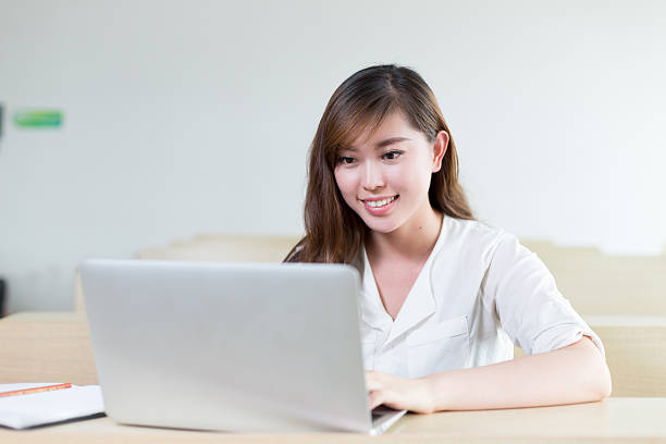 istock Asian  beautiful female student study with laptop in classroom 481380748