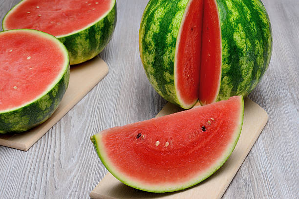 istock Watermelons sliced and cut in half, all on cutting board 481381154