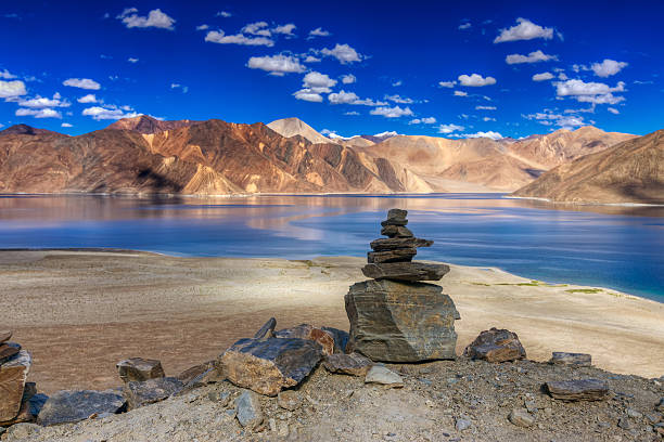 Mountains and rcoks , Pangong tso (Lake),Leh,Ladakh, India Rocks and reflection of Mountains on Pangong tso (Lake) with blue sky. It is huge lake in Ladakh, It is 134 km long and extends from India to Tibet. Leh, Ladakh, Jammu and Kashmir, India ladakh region stock pictures, royalty-free photos & images