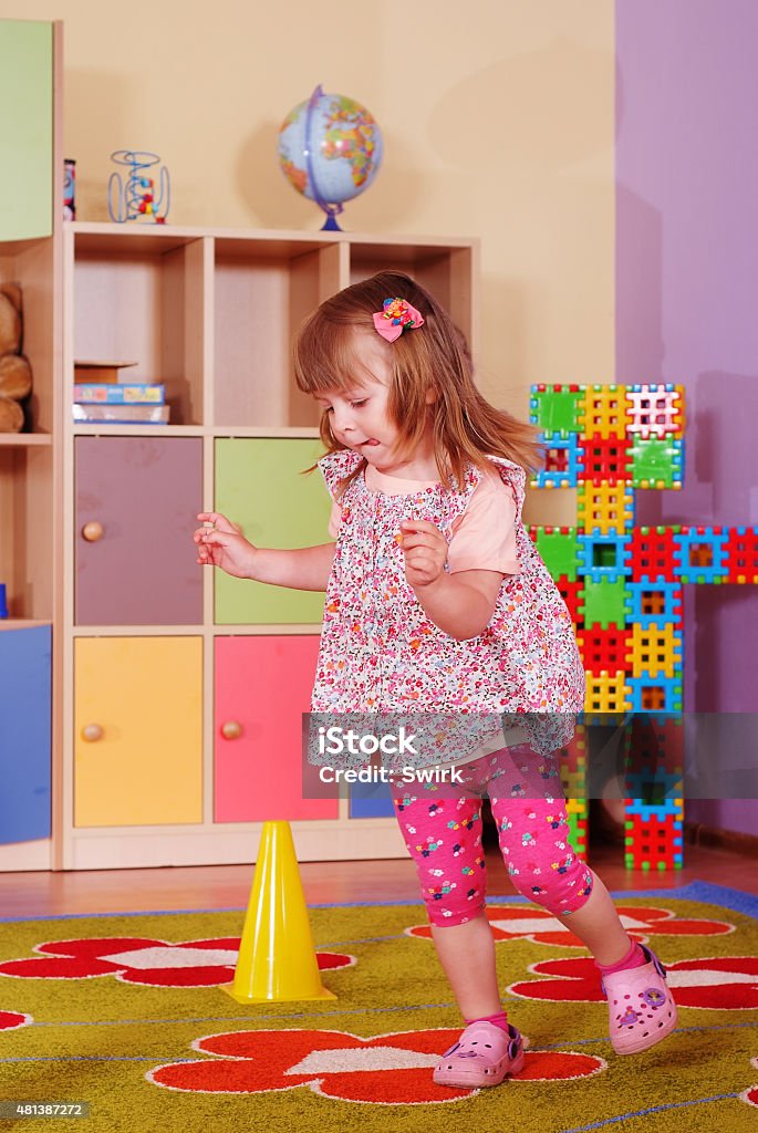 Two-year girl playing and learning in preschool Child in the nursery playing with hula hoops 2-3 Years Stock Photo