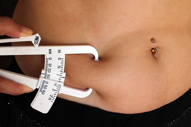 frau messung der body mass index über schieblehre - pierced jewelry women body stock-fotos und bilder