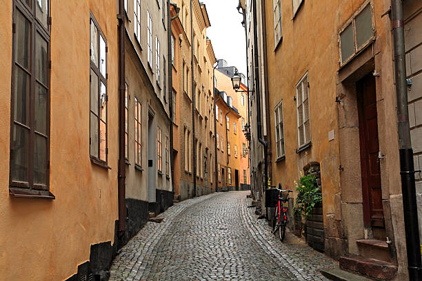 schmale geschwungene gepflasterten straße in der altstadt - stadsholmen stock-fotos und bilder