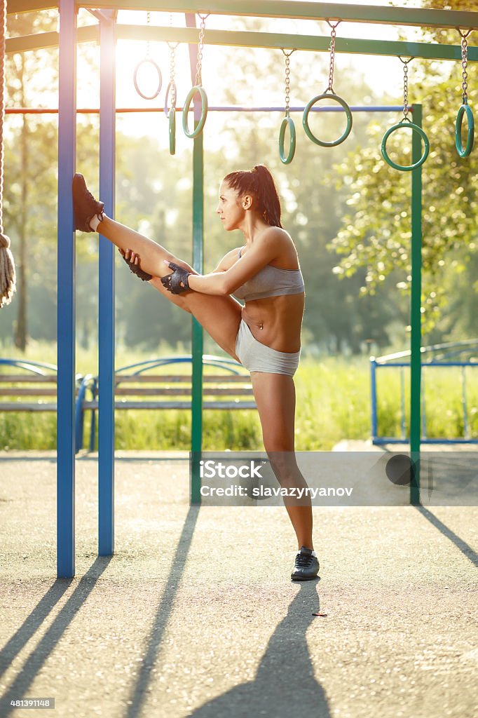 Pretty woman doing sport stretching exercises in the summer outdoor. 2015 Stock Photo