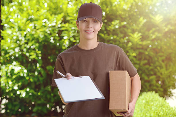 istock Smiling female courier delivering a parcel 481391292