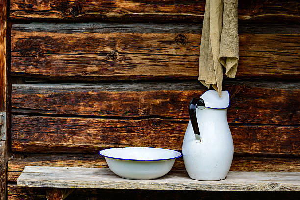 Place to wash up with white jug and bowl for water and a rugged cloth to dry with. Timber facade with copy space.