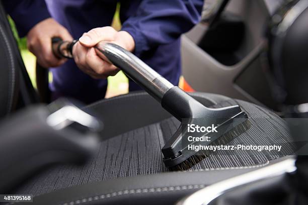 Photo libre de droit de Homme Hoovering Siège De Voiture Pour Un Nettoyage Voiture banque d'images et plus d'images libres de droit de Voiture