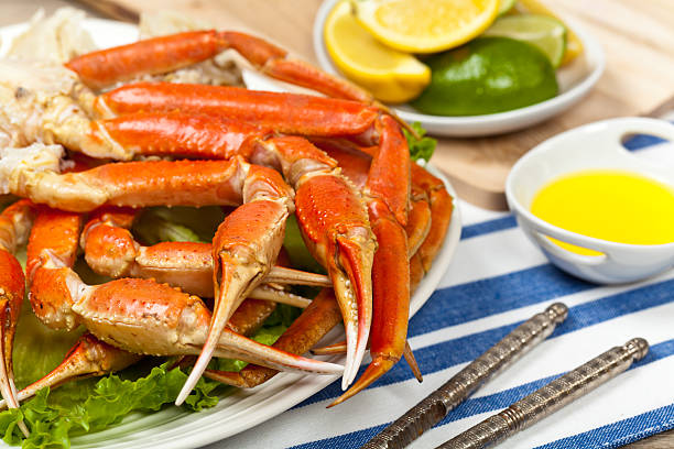 Crab legs Snow Crab legs with fresh lemon slices and butter sauce. Selective focus on claw. snow crab photos stock pictures, royalty-free photos & images