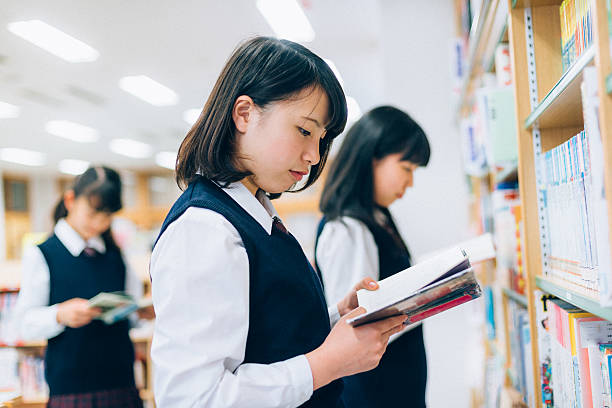 Japanese Female Students Reading in the Library Japanese Female Students reading in the School Library child japanese culture japan asian ethnicity stock pictures, royalty-free photos & images