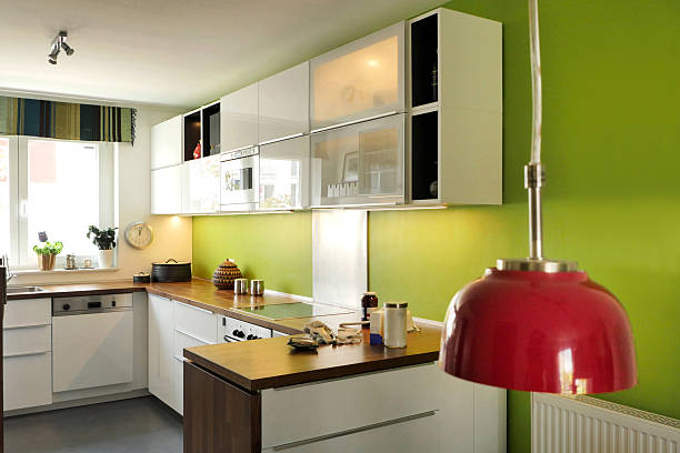 istock Open kitchen with baking utensils, green wall, wooden tabletop 481409934