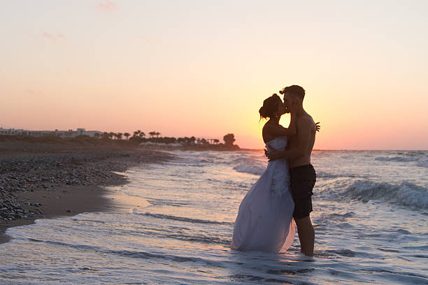 istock Just married young couple on a hazy beach at dusk 481409970