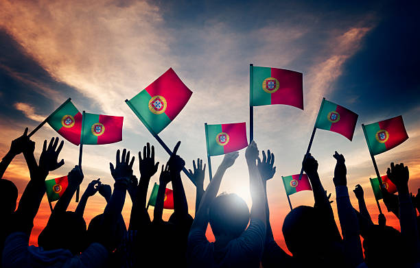 istock Group of People Waving Portuguese Flags in Back Lit 481410138