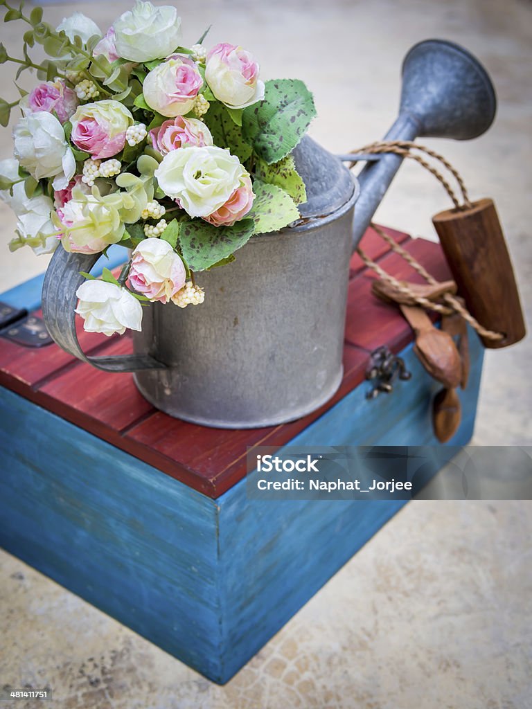 Artificial flowers decorate in  aluminium watering can with colorful box Beautiful artificial flowers decorate in  aluminium watering can with colorful box Aluminum Stock Photo