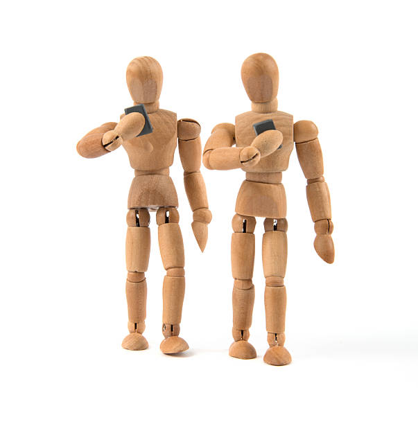 istock walking wooden mannequin looking only to smartphone 481413276