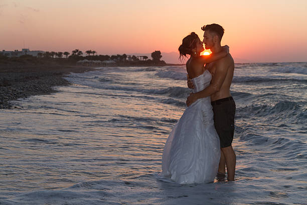 istock Just married young couple on a hazy beach at dusk 481414140