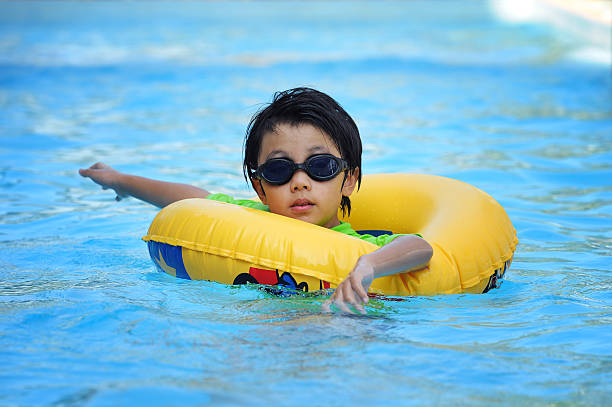ragazzo asiatico nella provetta imparare a nuotare - swimming tube inflatable circle foto e immagini stock
