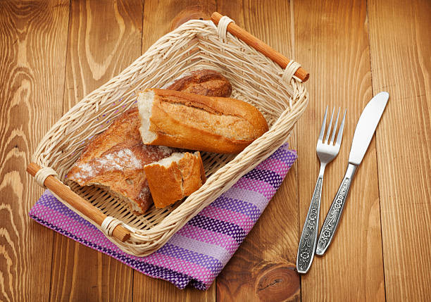 Various delicious freshly baked bread on a rustic wooden worktop.
