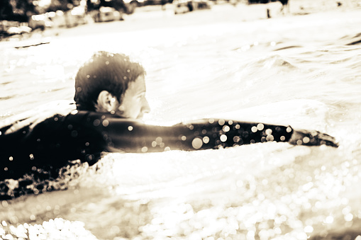 Portrait of a surfer swimming trough the water