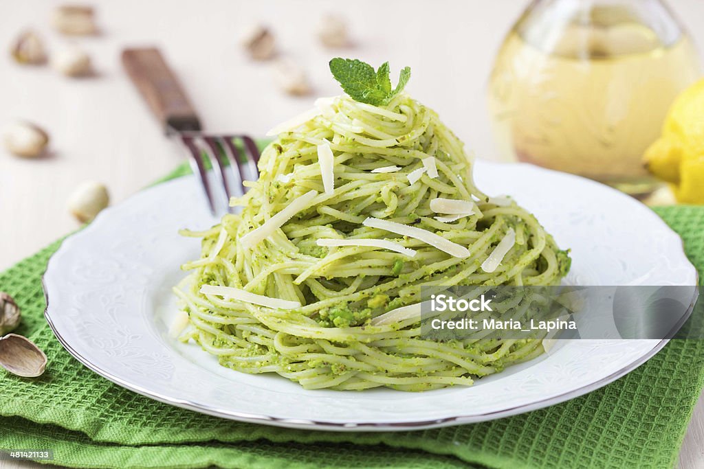 Italian pasta spaghetti with pesto green peas, mint, pistachios Italian green pasta spaghetti with pesto green peas, mint, pistachios, parmesan cheese, delicious healthy vegetarian appetizer Pasta Stock Photo