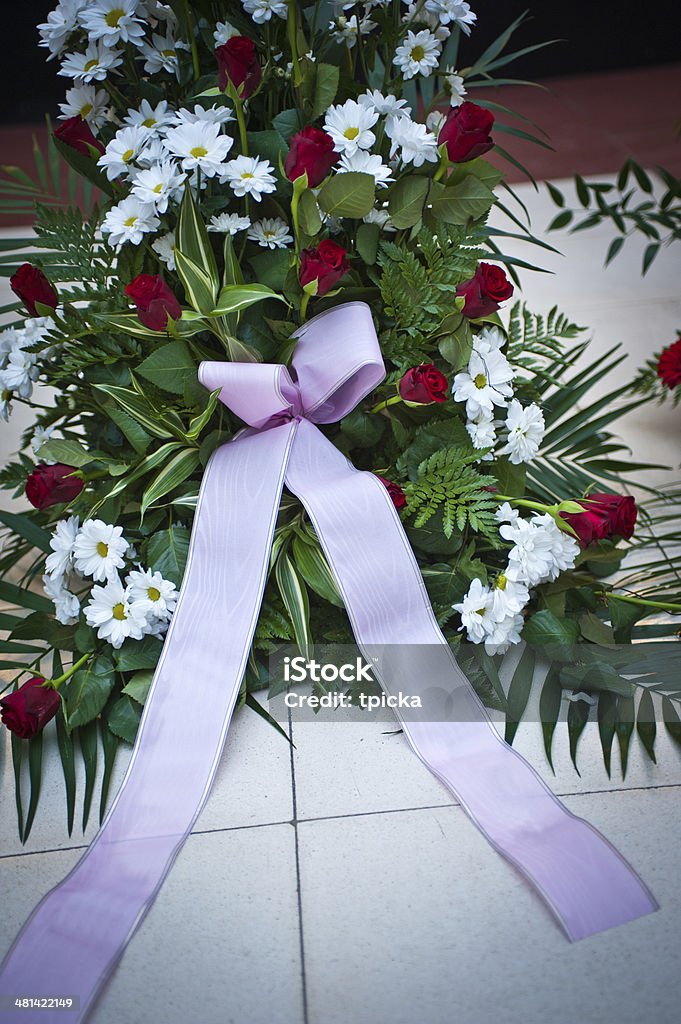 Funeral flowers Large funeral flowers in wreath with ribbon on floor Cremation Stock Photo