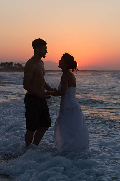 istock Just married young couple on a hazy beach at dusk 481423580