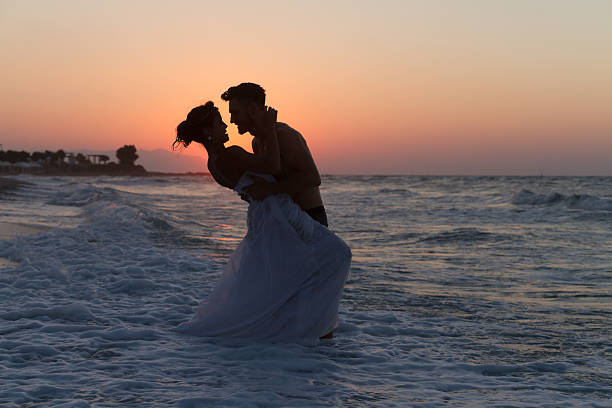 istock Just married young couple on a hazy beach at dusk 481423598