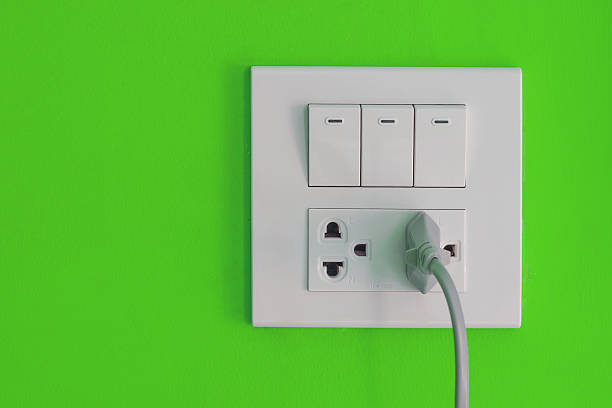 istock White electric outlet and switch mounted on blue wall 481428916
