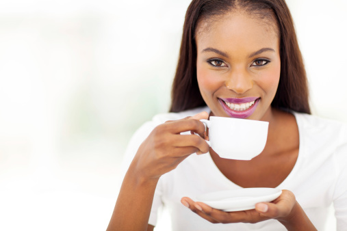 beautiful african american woman drinking coffee at home