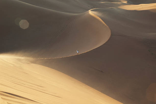 istock lonely man walking on a sand dune in the desert 481432841