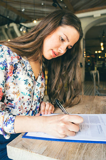 linda mulher de negócios, assinatura do contrato em um café em superfície de pavilhão - writing letter correspondence women imagens e fotografias de stock