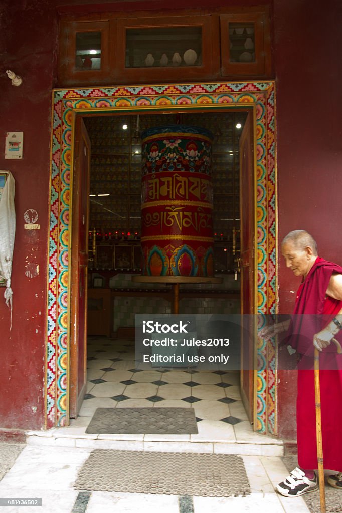 Old Tibetan Nun and prayer wheel, Mcleod Ganj, Dharansala, Dharamsala, India - September 11, 2014: Old Tibetan Nun and big prayer wheel in Mcleod Ganj, Dharansala, India 2015 Stock Photo